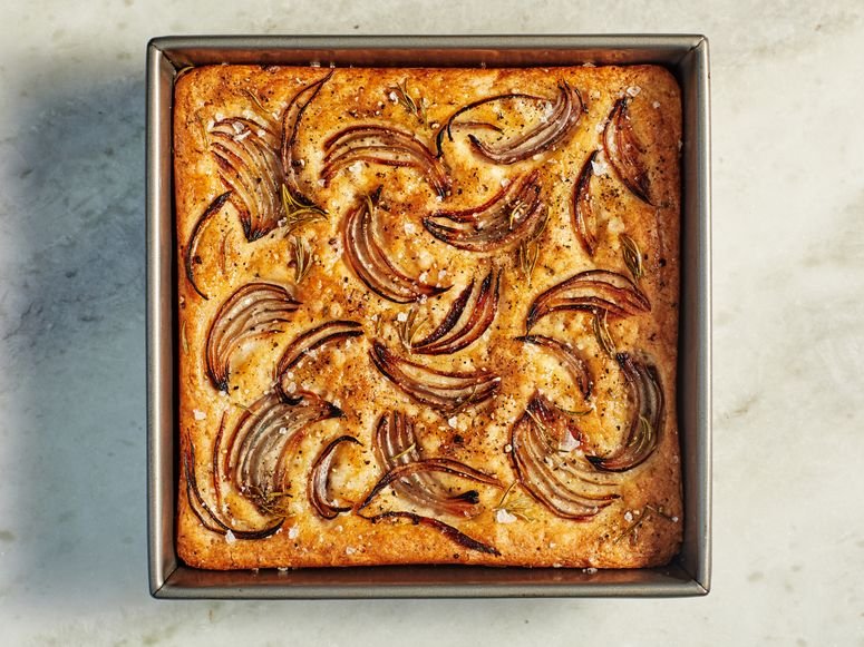 Red Onion and Rosemary Focaccia in a pan on a marble surface