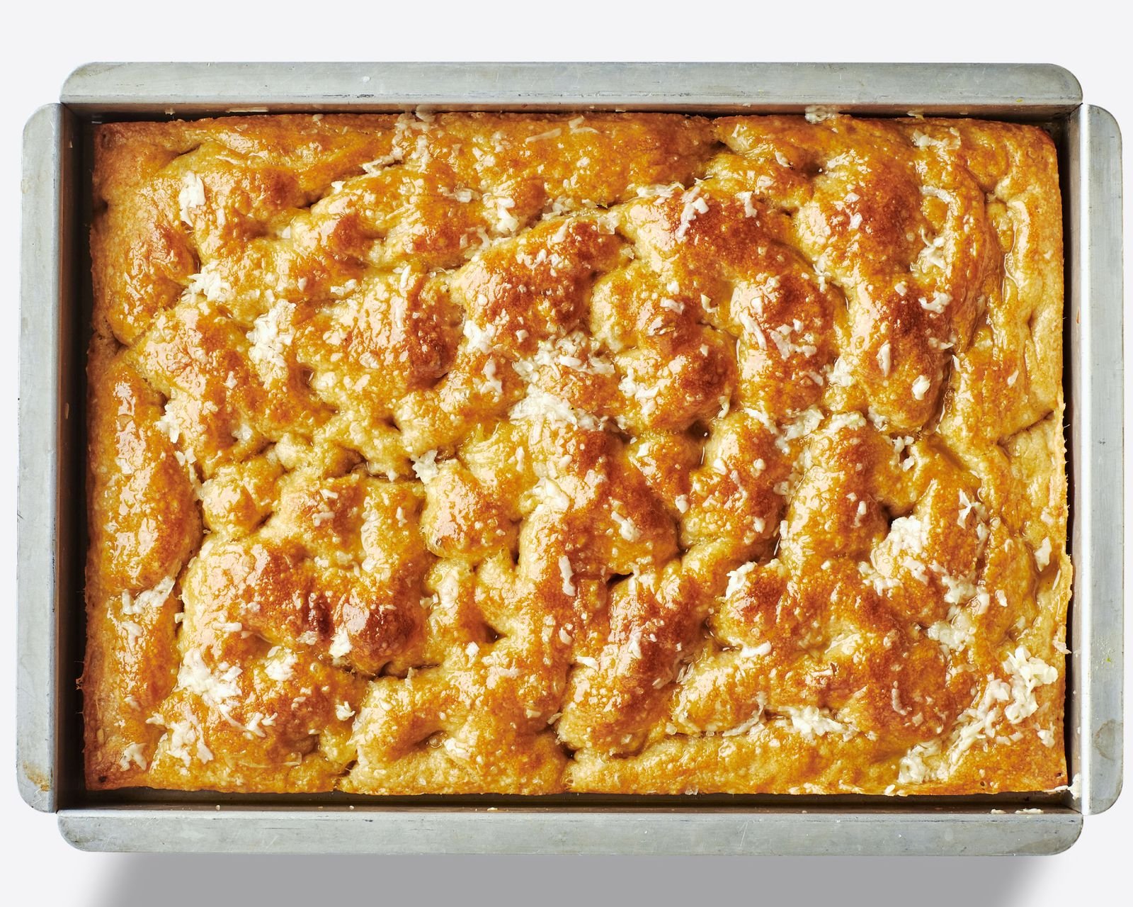 Goldenbrown noknead focaccia baked in a 13x9inch pan with a dimpled surface and flaky sea salt.